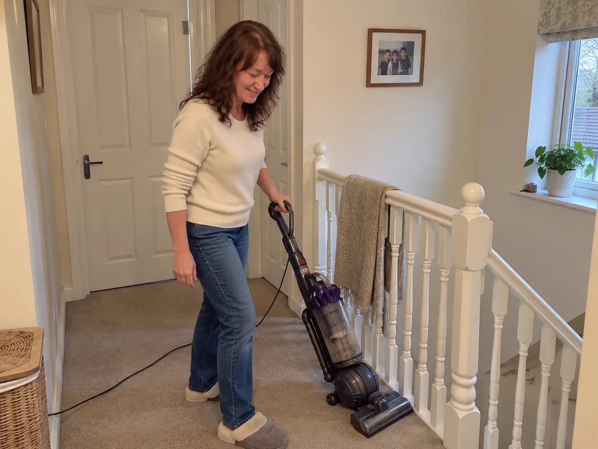 Illustrative scene of a woman finishing vacuuming the landing