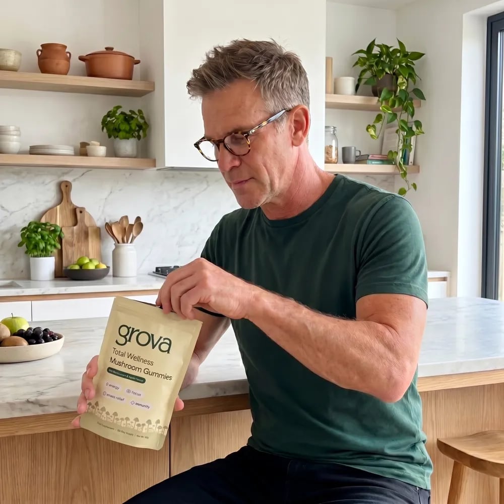 Man reaching into a pouch of Grova mushroom gummies in his kitchen
